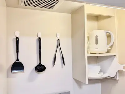 a kitchen with utensils hanging on the wall at Shinjuku \u9ad8\u7530\u99ac\u5834T AC in Tokyo