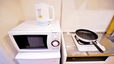 a frying pan is on top of a microwave at LJ Hotel Shinjuku in Tokyo