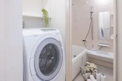 a white washing machine in a bathroom with a sink at DUA \u795e\u697d\u5742Shinjuku area,train 3 mins,waseda,Kagurazaka in Tokyo