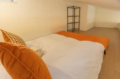 a bedroom with a bed with an orange and white blanket at DUA \u795e\u697d\u5742Shinjuku area,train 3 mins,waseda,Kagurazaka in Tokyo