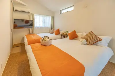 a bedroom with two beds with orange pillows at DUA \u795e\u697d\u5742Shinjuku area,train 3 mins,waseda,Kagurazaka in Tokyo