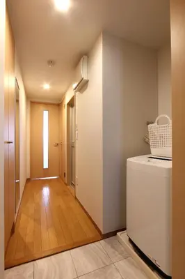 a laundry room with a washer and dryer and a hallway at \u30cb\u30e5\u30fc\u30ac\u30a4\u30a2 \u30ea\u30eb\u30fc\u30e0\u829d No27 - \u6771\u4eac\u30bf\u30ef\u30fc,\u829d\u516c\u5712\u3082\u5f92\u6b69\u570f\u5185 - \u7fbd\u7530\u76f4\u901a - \u5c71\u624b\u7dda\u5229\u7528 in Tokyo
