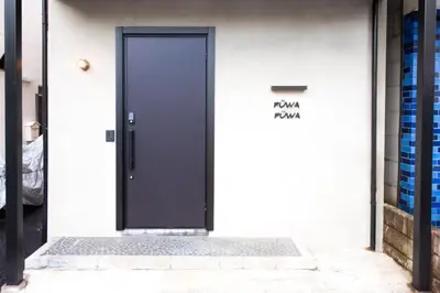 a black door on the side of a white building at \uff26\uff55\uff57\uff41\uff26\uff55\uff57\uff41 in Tokyo