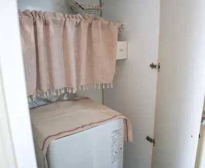 a laundry room with a washer and dryer and a curtain at kikinoie little room \u30c7\u30a3\u30ba\u30cb\u30fc\u30ea\u30be\u30fc\u30c8\u307e\u3067\u8eca\u306715\u5206 in Ichikawa