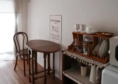 a kitchen with a table and chairs and a shelf at kikinoie little room \u30c7\u30a3\u30ba\u30cb\u30fc\u30ea\u30be\u30fc\u30c8\u307e\u3067\u8eca\u306715\u5206 in Ichikawa