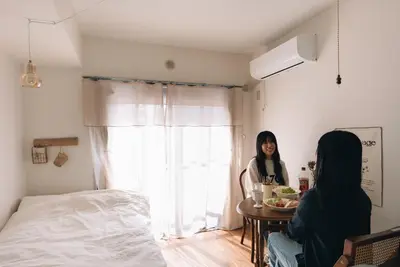 two women sitting at a table in a bedroom at kikinoie little room \u30c7\u30a3\u30ba\u30cb\u30fc\u30ea\u30be\u30fc\u30c8\u307e\u3067\u8eca\u306715\u5206 in Ichikawa