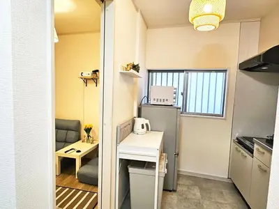 a small kitchen with a table and a refrigerator at New #\ud3b8\uc758\uc81010\ucd08#\uc2e0\uc8fc\ucfe02\ubd84#\uc2e0\uc624\ucfe0\ubcf4\uc5ed5\ubd84#16\ud3c9#\ucd5c\ub3004\uba85#\ubd80\uc5cc\uce68\uc2e4#\ub098\ub9ac\ud0c0\uacf5\ud56d50\ubd84#\uc544\ub291\ud55c\uc544\ud30c\ud2b8#\uace0\uae09\ub9e4\ud2b8\ub9ac\uc2a4 in Tokyo