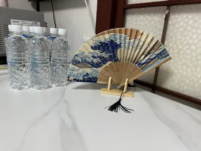 a fan and bottles of water on a table at \u6d45\u8349 \u30b9\u30ab\u30a4\u30c4\u30ea\u30fc\u570f10\u5206 \u4ea4\u901a\u81f3\u4fbf \u6d45\u8349\u5bfa\u89b3\u5149\u30fc\u53cc\u9b5a\u30ce\u5bbf\u5357\u68df in Tokyo