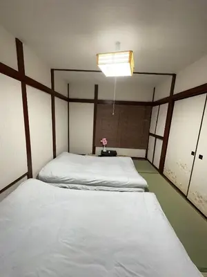a bedroom with two beds and a lamp at \u6d45\u8349 \u30b9\u30ab\u30a4\u30c4\u30ea\u30fc\u570f10\u5206 \u4ea4\u901a\u81f3\u4fbf \u6d45\u8349\u5bfa\u89b3\u5149\u30fc\u53cc\u9b5a\u30ce\u5bbf\u5357\u68df in Tokyo