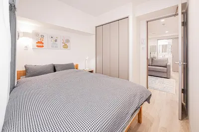 a bedroom with a bed with a black and white comforter at self-check in misimaya building in Tokyo