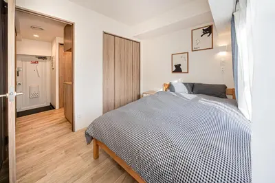 a bedroom with a large bed and a hallway at self-check in misimaya building in Tokyo