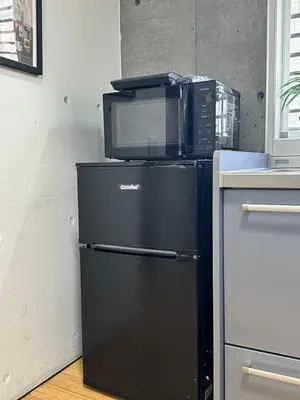 a microwave sitting on top of a refrigerator at \u5de3\u9d28Sapmt in Tokyo