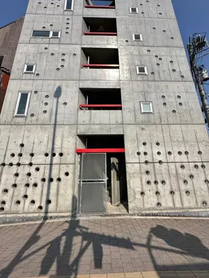 a tall concrete building with an open door at \u5de3\u9d28Sapmt in Tokyo
