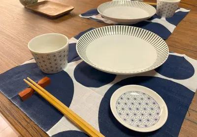a table with plates and chopsticks on a table at 6 Min Walk from Aoto Station, Direct Access to Narita, Haneda Airports, Old house with modern renovation, in Tokyo
