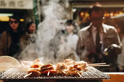 a group of food cooking on a grill with smoke at 6 Min Walk from Aoto Station, Direct Access to Narita, Haneda Airports, Old house with modern renovation, in Tokyo