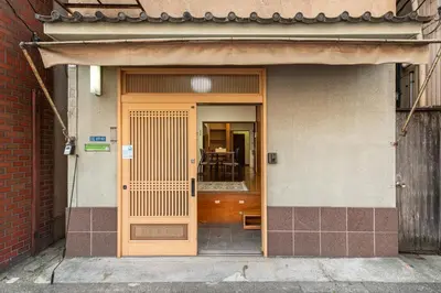 an entrance to a building with a wooden door at \u6d45\u8349\u4e09\u4e01\u76ee\u6238\u5efa\u3066 in Tokyo