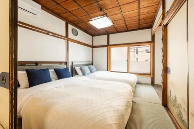 a bedroom with two beds and a window at \u6d45\u8349\u4e09\u4e01\u76ee\u6238\u5efa\u3066 in Tokyo