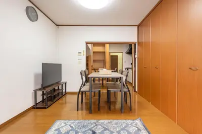 a dining room with a table and chairs and a tv at \u6d45\u8349\u4e09\u4e01\u76ee\u6238\u5efa\u3066 in Tokyo