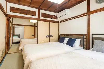 three beds in a room with wooden ceilings at \u6d45\u8349\u4e09\u4e01\u76ee\u6238\u5efa\u3066 in Tokyo