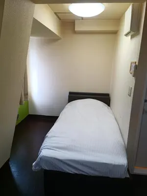 a small bedroom with a white bed in it at Ace Inn Asakusa in Tokyo