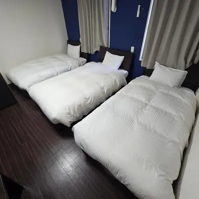 two beds in a room with white sheets at Ace Inn Asakusa in Tokyo