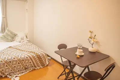 a bedroom with a bed and a table with chairs at shinjuku 2 stops,3-4 people,train walk for 5mins in Tokyo