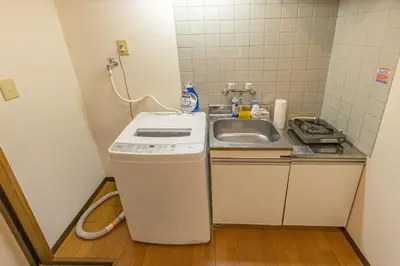 a small kitchen with a sink and a washing machine at shinjuku 2 stops,3-4 people,train walk for 5mins in Tokyo