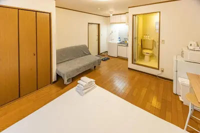 a living room with a bed and a bathroom at shinjuku 2 stops,3-4 people,train walk for 5mins in Tokyo
