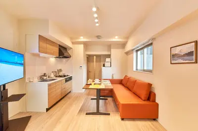 a living room with an orange couch and a table at Nomadland Shinagawa Omori 1004 in Tokyo