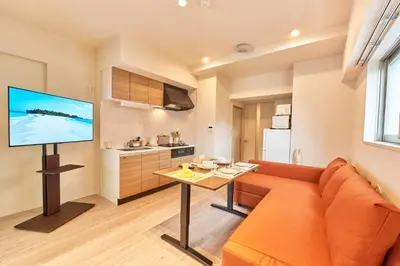 a living room with a couch and a table with a television at Nomadland Shinagawa Omori 1004 in Tokyo