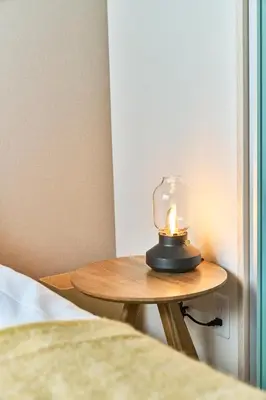 a candle on a small table next to a bed at Nomadland Shinagawa Omori 1004 in Tokyo