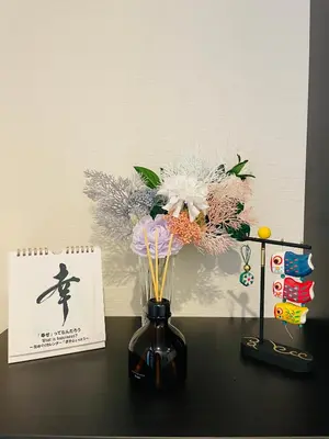 a vase with flowers on a table next to a card at Sakae House in Tokyo