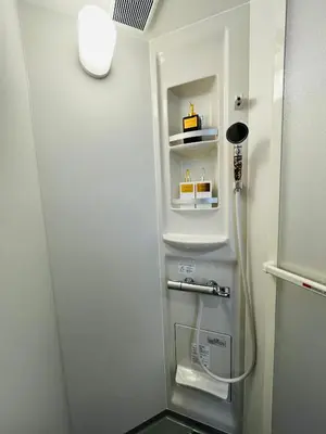 a small bathroom with a shower with a refrigerator at Sakae House in Tokyo
