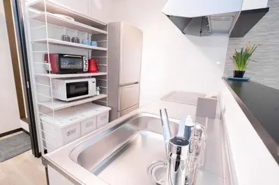 a kitchen with a sink and a microwave at Sakae House in Tokyo
