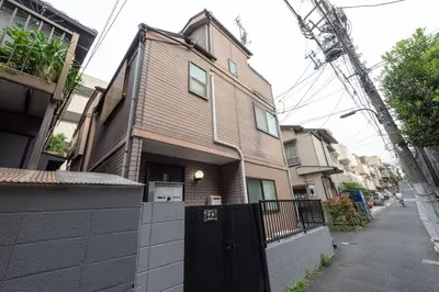 a brown house with a black gate on a street at \u697d\u9038 \u4e2d\u4e95 104t in Tokyo