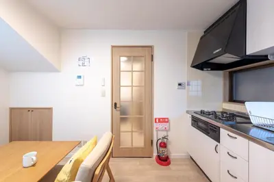 a kitchen with a table and a stove top oven at \u697d\u9038 \u4e2d\u4e95 104t in Tokyo