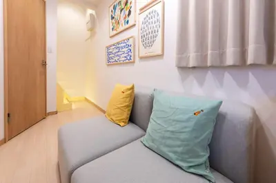 a living room with a couch and a pillow at \u697d\u9038\u30b0\u30eb\u30fc\u30d7Skytree 105T in Tokyo