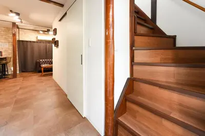a hallway with wooden stairs in a house at \u5b50\u732b\u306e\u5bb6 103t in Tokyo