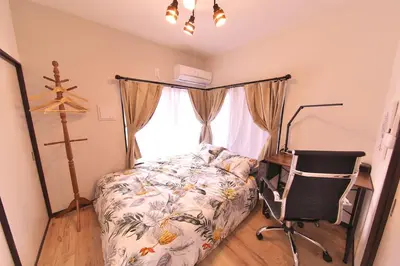 a bedroom with a bed and a chair and a window at Y's INN 池袋西 029T in Tokyo