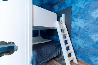 a bunk bed in a room with clouds mural at Fantasy Lodge in Tokyo