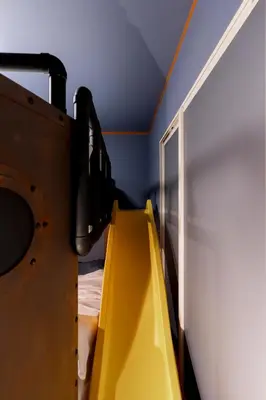 a room with a yellow slide in a room at Fantasy Lodge in Tokyo