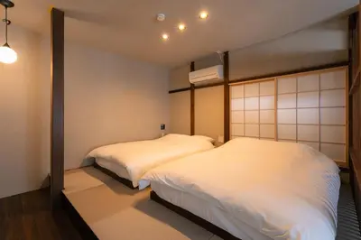 two beds in a room with white sheets at ERA 1927 Koenji in Tokyo