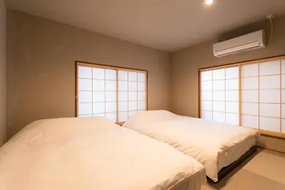 two beds in a room with two windows at ERA 1927 Koenji in Tokyo