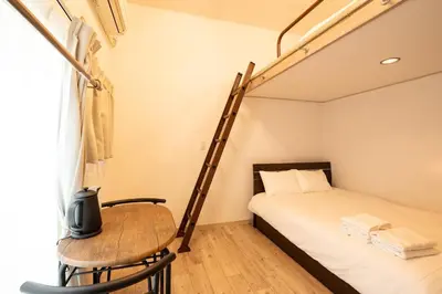 a bedroom with a bunk bed with a table and a chair at \u30b9\u30ef\u30f3\u30d1\u30fc\u30af\u6c60\u888b in Tokyo