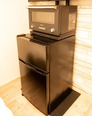 a microwave oven sitting on top of a refrigerator at \u30b9\u30ef\u30f3\u30d1\u30fc\u30af\u6c60\u888b in Tokyo