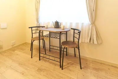 a small table and chairs in a room with a window at \u30b9\u30ef\u30f3\u30d1\u30fc\u30af\u6c60\u888b in Tokyo