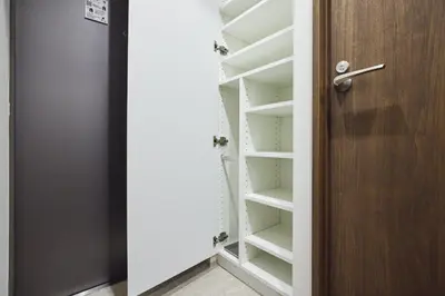 a closet with white shelves and a wooden door at Miyabi \u795e\u697d\u5742 in Tokyo