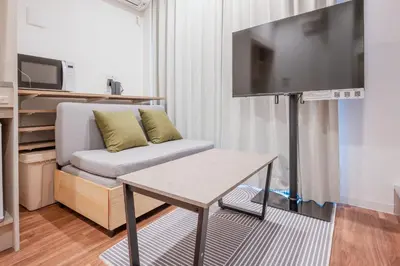 a living room with a couch and a flat screen tv at Hit\u9326\u7cf8\u753a in Tokyo