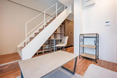 a staircase in a room with a chair and a table at Hit\u9326\u7cf8\u753a in Tokyo