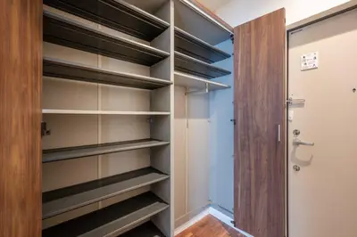 a walk in closet with wooden shelves and a door at Hit\u9326\u7cf8\u753a in Tokyo